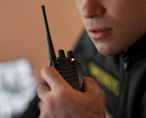 A man holding a two-way radio accessoried with an antenna