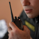 A man holding a two-way radio accessoried with an antenna