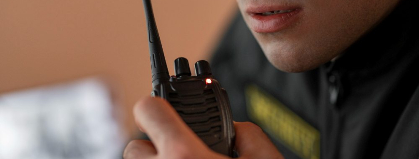 A man holding a two-way radio accessoried with an antenna