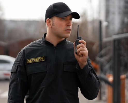 A guard using a two-way radio to handle the vehicle parking outside a sports venue