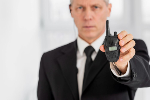 A person holding a compact two-way radio