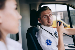 A person holding a black two-way radio while driving