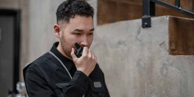 A person holding a black two-way radio