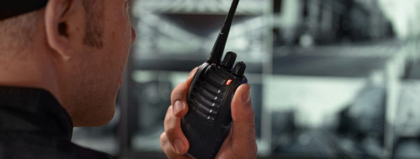 A man holding a black two-way radio